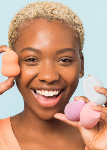 smiling girl holding four sponges, one in each color